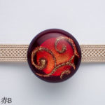 光を反射するオーナメントの帯留めスワール少々難　赤B正面図